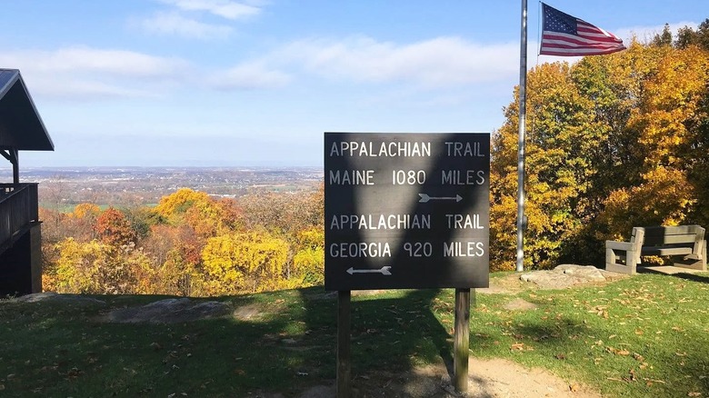 A sign for the Appalachian Trail in a mountain park in Maryland, featuring expansive views of a valley covered in foliage.