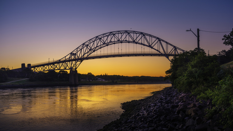 Sunrise over Sagamore Bridge along the Cape Cod Canal, vibrant purples and gold in the sky