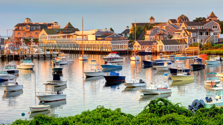 View of a marina and boats docked in Harwich, Massachusetts on Cape Cod with homes in the backdrop