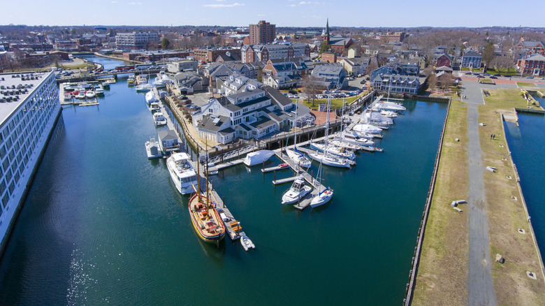 An aerial view of Pickering Wharf shows boats, buildings, and a couple of strollers on a sunny day in Salem, Massachusetts