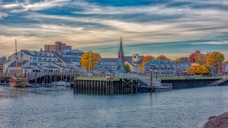 An autumnal skyline of Pickering Wharf in Salem, Massachusetts is viewed from the opposite shore