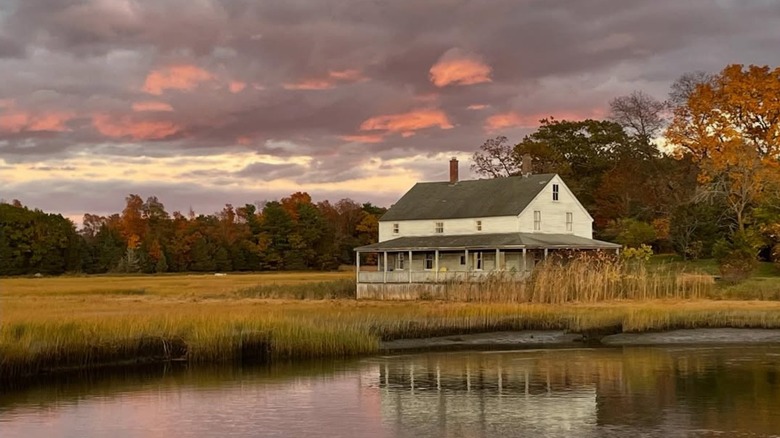 White building overlooking water at sunset in Essex