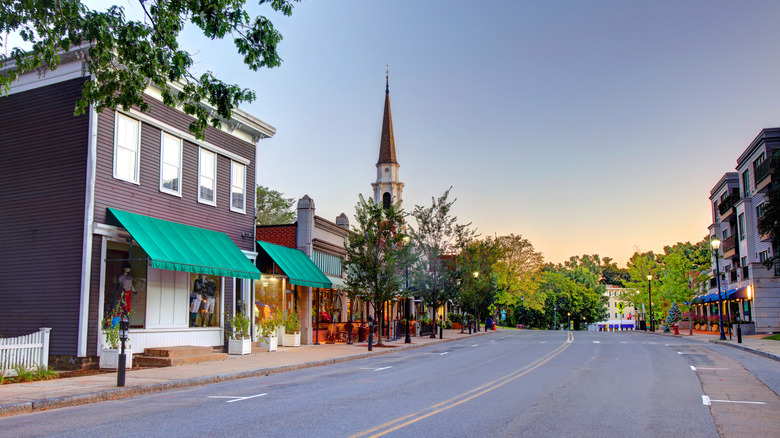View of shops, restaurants, and a church steeple in Wellesley, Mass at sunset
