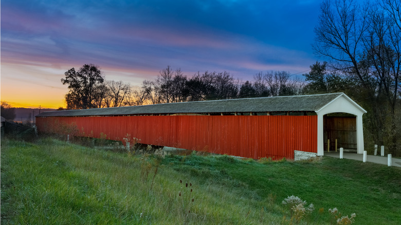 The Medora Covered Bridge at sunset surrounded by grass and trees