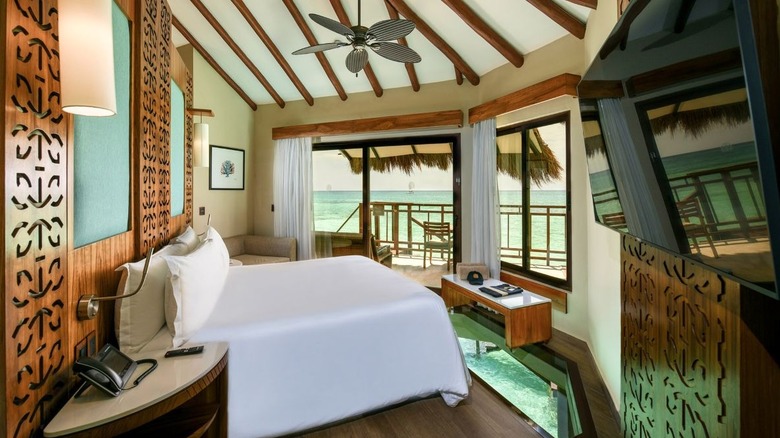 Palafitos Overwater Bungalows room interior with bed, TV, and amenities, Maroma Beach, Riviera Maya, Mexico