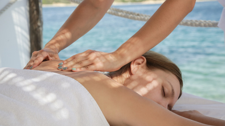 Woman being massaged by the beach