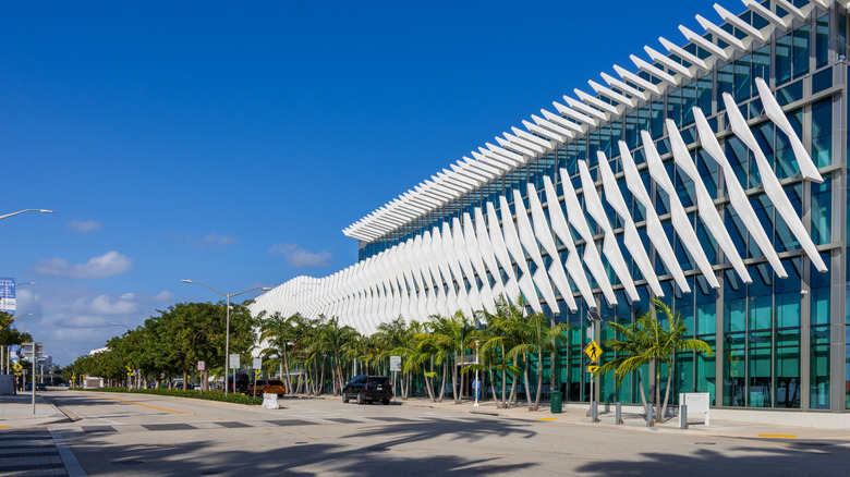 The Miami Beach Convention Center with a blue sky and palm trees