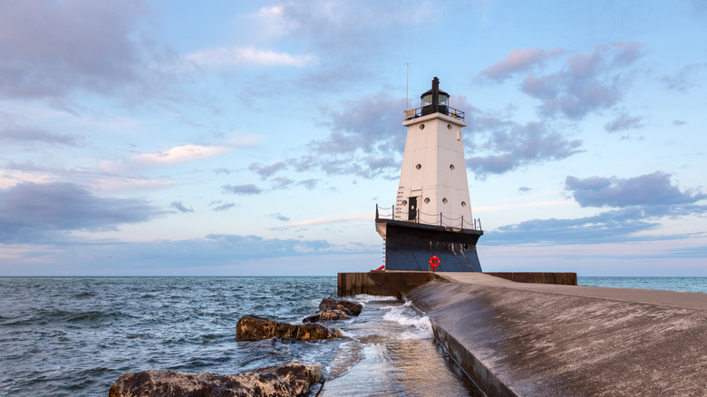 The Ludington North Breakwater Pier and lighthouse stretching out into Lake Michigan, the sun low in the sky