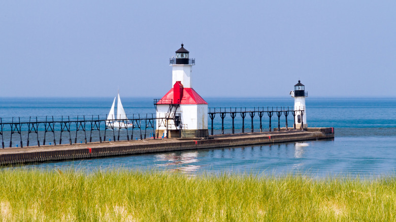 The St. Joseph North Pier on Lake Michigan with a sailboat in the background