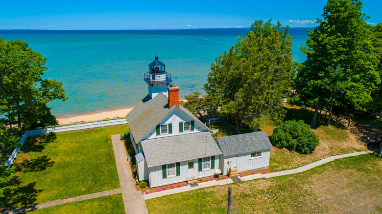 Quaint house and small tower of Mission Point with aqua blue Lake Michigan in the background