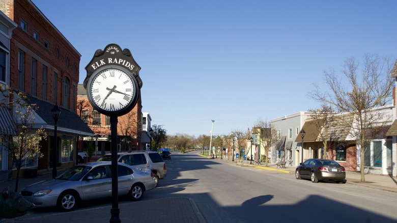 Main Street in the village of Elk Rapids in Northern Michigan with an old longcase clock and parked cars