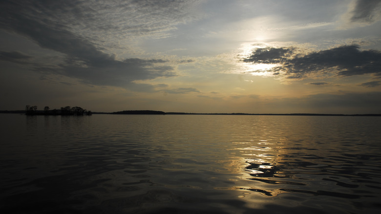 A still Manistique Lake reflecting the ascending sun in Curtis, Michigan