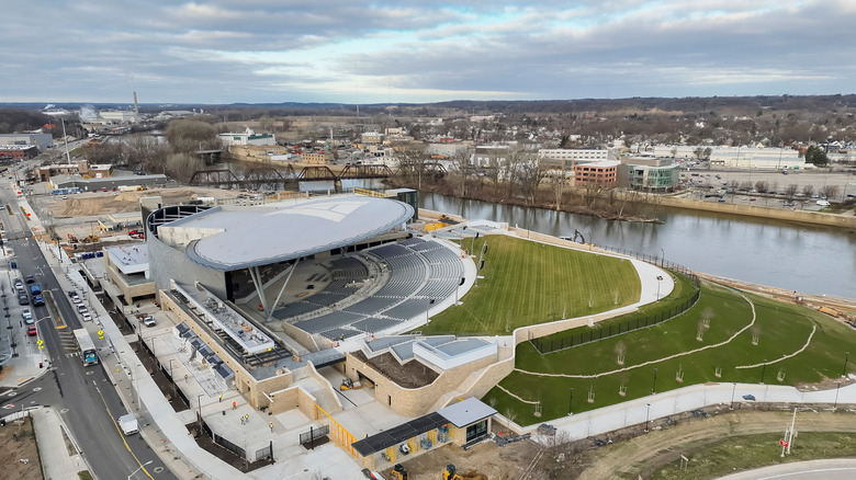 Aerial view of Acrisure Amphitheater, showing its elliptical canopy, seating, and riverside location