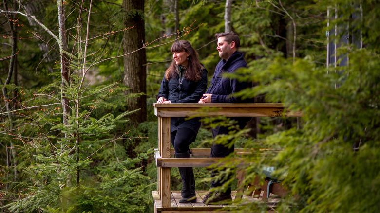 Couple standing on a deck in the woods