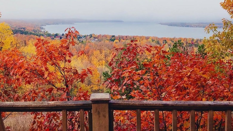 A view of Lake Charlevoix from an observation point, with a wooden fence in the foreground