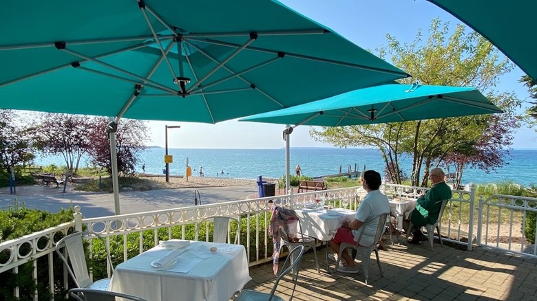 People dining on a patio near the shore of Lake Michigan at Blu in Glen Arbor, Michigan