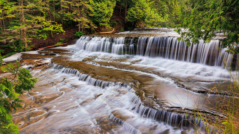 Water cascading over layers of rocks at Au Train Falls in Michigan