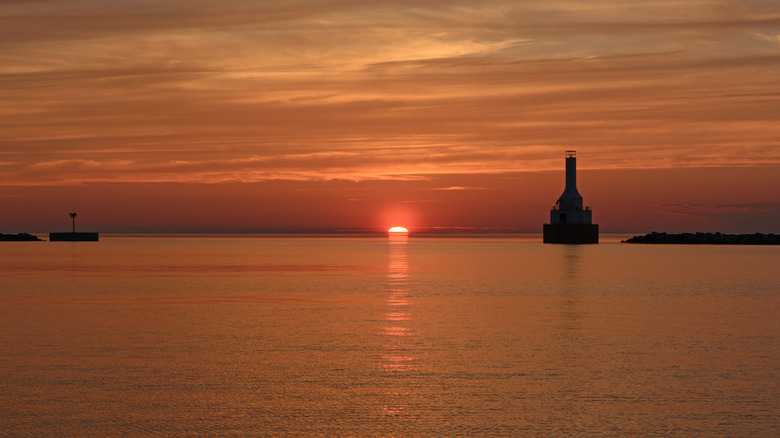 Sunset on Lake Superior with the Keweenaw Waterway Lighthouse in the background at McLain State Park, Michigan