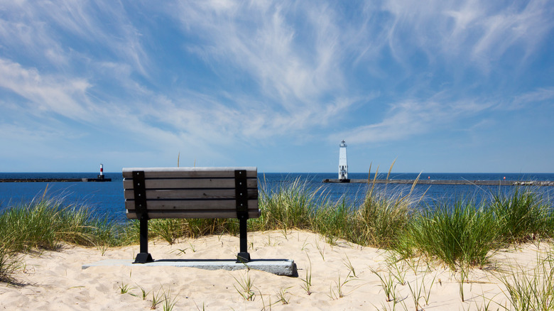 Park bench on a sandy dune facing the Point Betsie Lighthouse