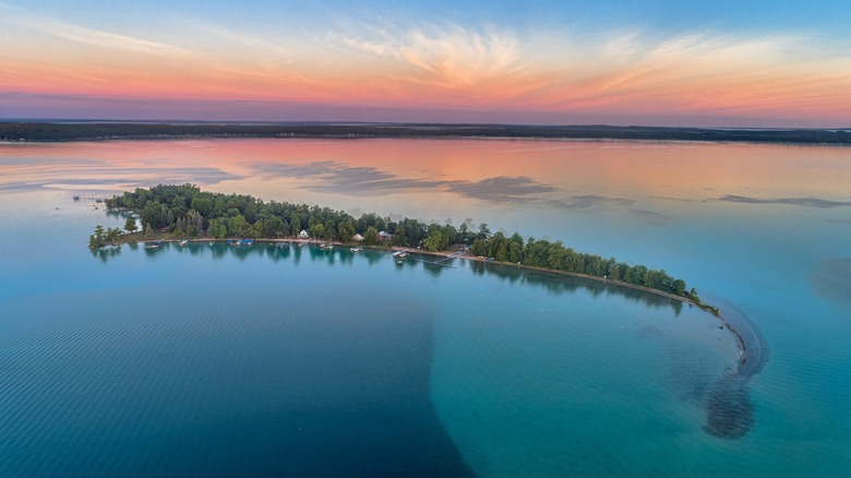 Crystal clear blue waters of Higgins Lake with colorful sunset