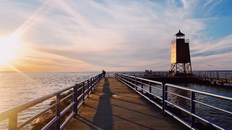 Boardwalk and lighthouse on Lake Charlevoix during sunset