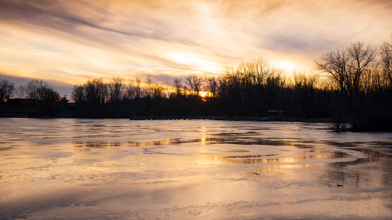 Reeds Lake freezing over under sunset