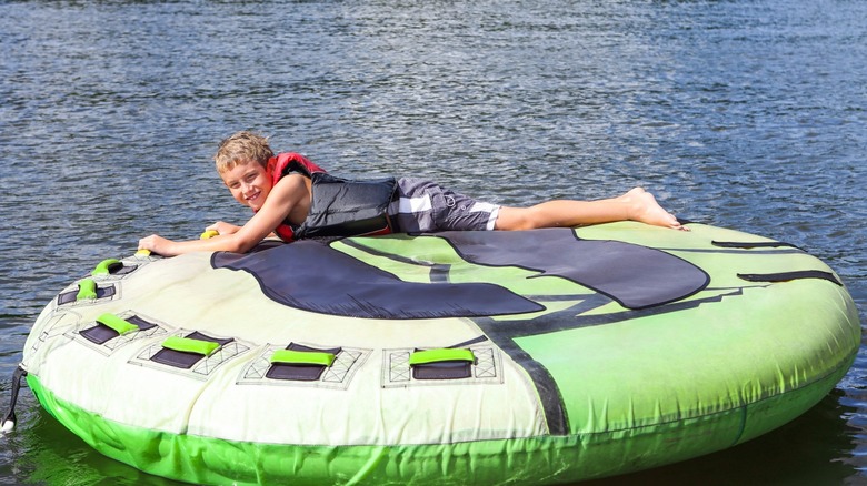 A young boy tubes on a lake
