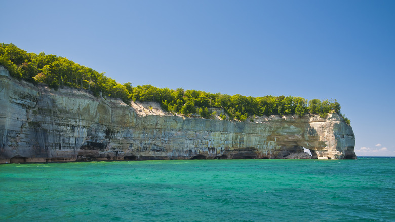 turquiose lake with tall cliffs in the background