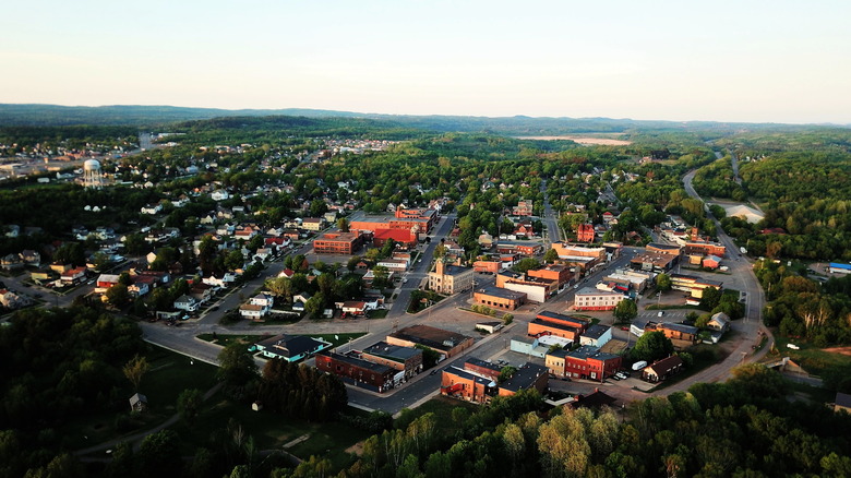 An aerial photo of Negaunee at sunset, with the few downtown streets lined with brick buildings and forest stretching forever all around