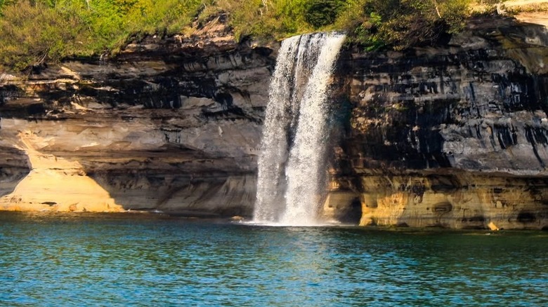 A view of Spray Falls, a waterfall plunging from cliffs into Lake Superior