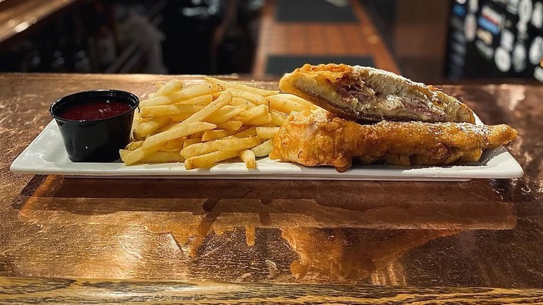 A sandwich and fries on a bar