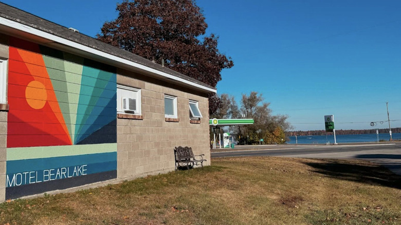 the outside of Motel Bear Lake, showing a colorful mural and a lake in the background