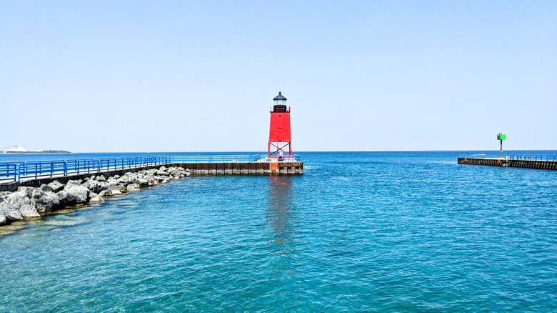 Red lighthouse at end of pier in lake