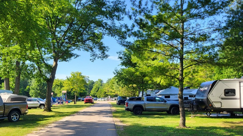 One of the campgrounds at Lakeport State Park with a paved road, leafy trees, and campers on bother sides
