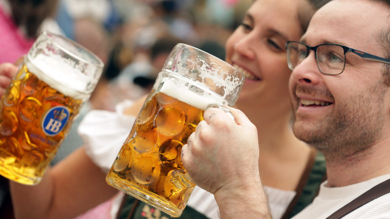 Man and woman holding up beer steins