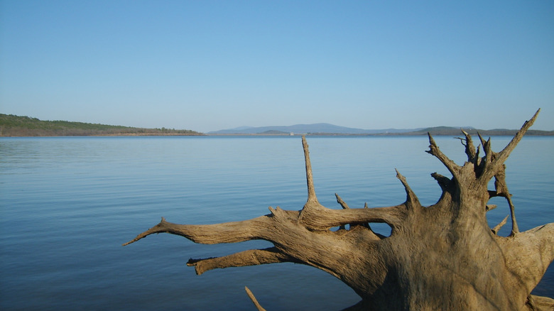 The placid Wister Lake in Oklahoma with land and mountains in the distance.