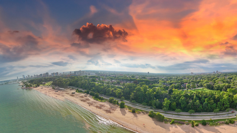 An aerial view of Bradford Beach and Lake Michigan at sunset with the Milwaukee skyline in the background
