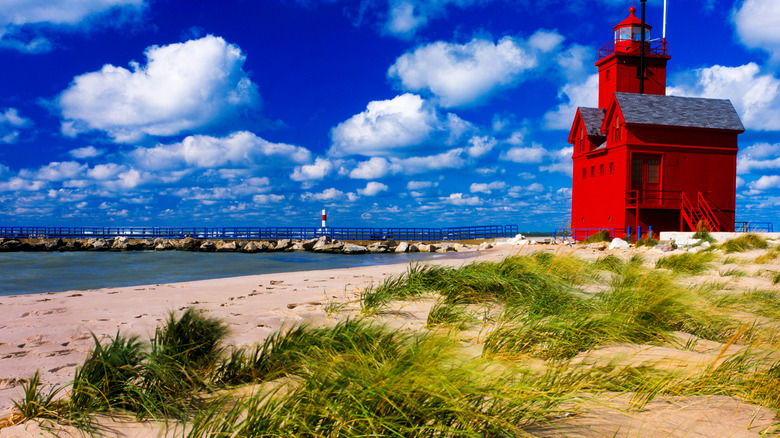 The Big Red Lighthouse in Holland State Park Beach with grasses and white sand