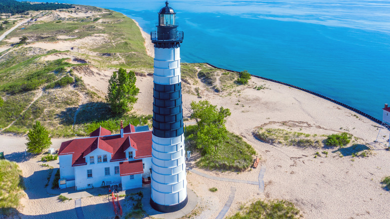 An aerial view of Big Sable Point Lighthouse surrounded by Ludington State Park Beach and Lake Michigan