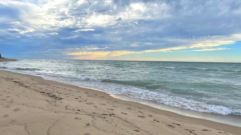 Oval Beach on Lake Michigan with gentle waves lapping and footprints in the sand