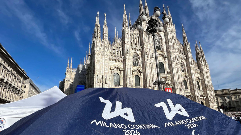 A tent with the Milano Cortina logo in front of the Milan Duomo