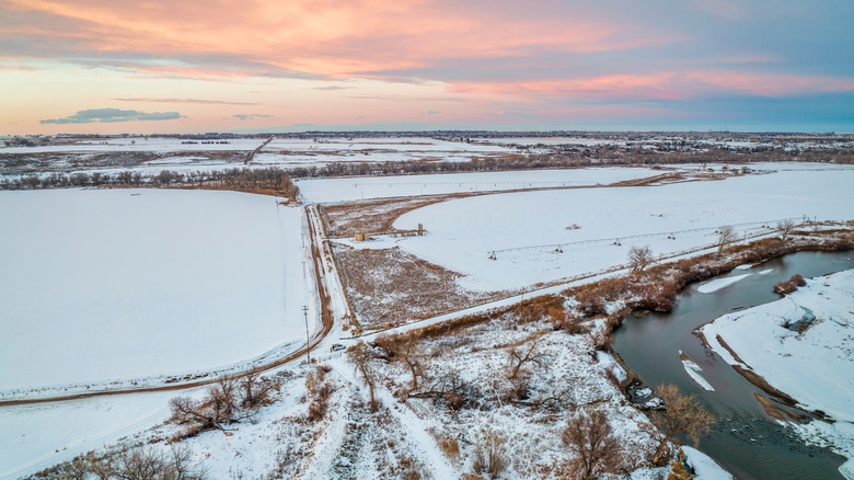 Snowy sunset aerial view of river and farmland near Milliken
