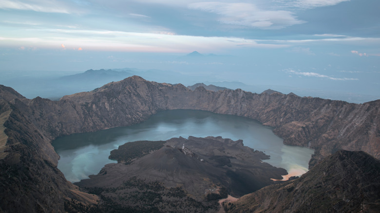 Sunrise over Segara Anak and its crater lake in a caldera by Mount Rinjani, in Lombok, Indonesia