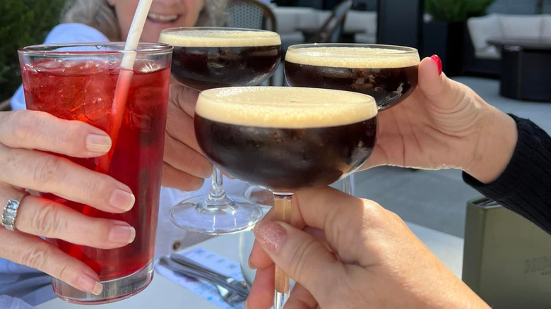 hands clinking cocktails together at Bridgewater Grill in Milwaukee