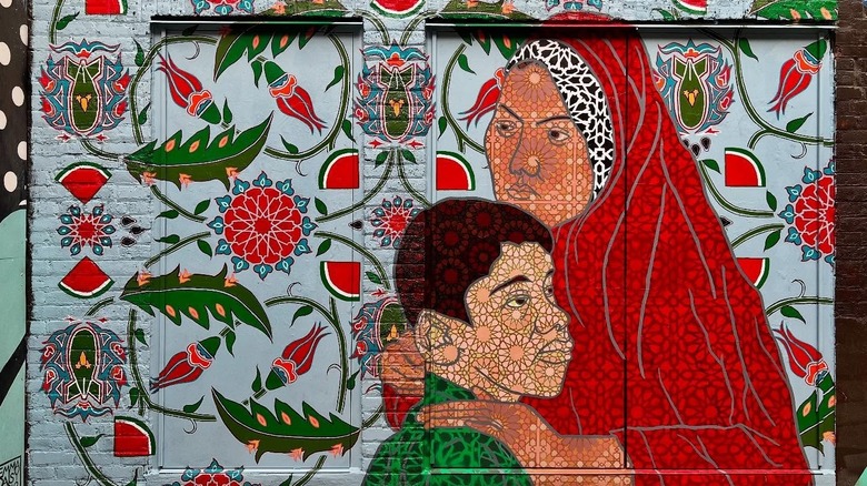 Mural of a woman holding a boy with mosaic-like detailing in Milwaukee's Black Cat Alley