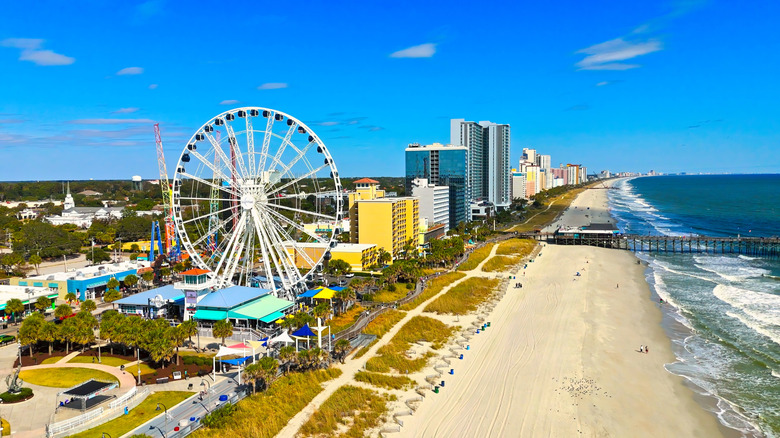 A Ferris Wheel rises above white sand and hotels at Myrtle Beach.