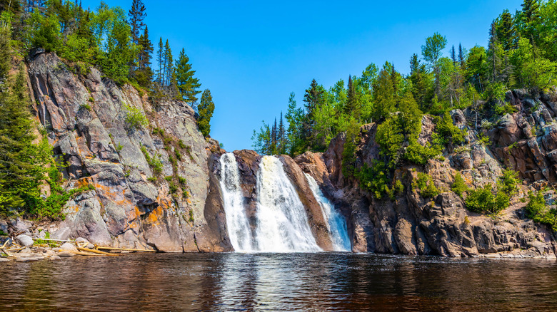 High Falls cascading into a natural pool surrounded by trees and cliffs.