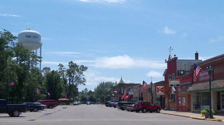 A view of Pine City with storefronts, trees, and a water tower