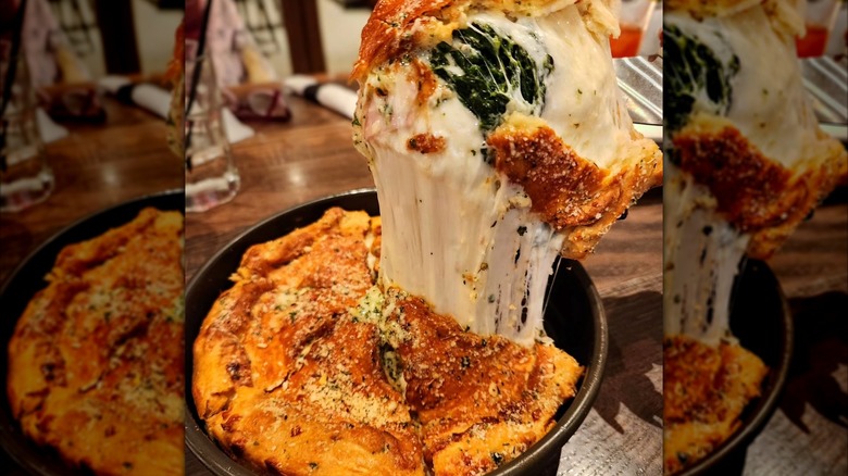 Rush Street Stuffed Pizza from Green Mill, brushed with garlic butter, sprinkled with herb parmesan, and packed with Canadian bacon, spinach, garlic