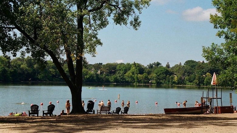 People and families at sandy beach on lake